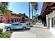 A street view showing storefronts with colorful buildings, palm trees, and parked cars under a clear sky at 4227 Placid Dr, Sarasota, FL 34243