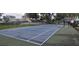 Outdoor tennis court with a blue surface and classic white lines, surrounded by a black fence at 4227 Placid Dr, Sarasota, FL 34243