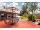 Inviting backyard featuring a patio set under a colorful umbrella, complemented by lush landscaping and tropical plants at 4303 83Rd W St, Bradenton, FL 34209