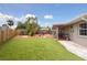 Large backyard featuring artificial turf, mature landscaping, and outdoor seating areas at 4303 83Rd W St, Bradenton, FL 34209