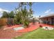 Spacious backyard area with mature tropical trees, colorful landscaping, and outdoor seating at 4303 83Rd W St, Bradenton, FL 34209