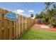 Fenced backyard with artificial turf, mature trees, and a patio area perfect for relaxing at 4303 83Rd W St, Bradenton, FL 34209