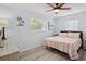 Bright bedroom featuring a ceiling fan, wood-look floors, and a comfortable bed with a striped comforter at 4303 83Rd W St, Bradenton, FL 34209