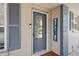 Close-up of the front door with decorative glass, stylish shutters, and a 
