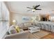 Cozy living room area with a ceiling fan, comfortable seating, and a view of the kitchen at 4303 83Rd W St, Bradenton, FL 34209