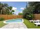 Backyard pool surrounded by lush landscaping, a wood fence, and lounge chairs for relaxation at 4303 83Rd W St, Bradenton, FL 34209