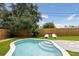 Backyard pool with surrounding green lawn, bordered by a wooden fence for privacy, and lawn furniture at 4303 83Rd W St, Bradenton, FL 34209