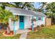 Exterior of building showcasing colorful flowers, bright teal door and shutters at 4528 58Th W St, Bradenton, FL 34210