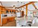 Kitchen with wood cabinets, island with cooktop, and seamless transition to the living room at 4528 58Th W St, Bradenton, FL 34210
