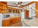 Well-lit kitchen with wood cabinets, a tile countertop, and seamless access to the adjoining living area at 4528 58Th W St, Bradenton, FL 34210
