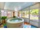 Enclosed sunroom featuring a hot tub and backyard view at 4528 58Th W St, Bradenton, FL 34210