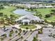 Aerial view of the community clubhouse, parking, and golf course with water features at 4720 Arpino Ct, Bradenton, FL 34211