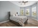Inviting bedroom featuring a ceiling fan, three bright windows, and hardwood floors at 4720 Arpino Ct, Bradenton, FL 34211