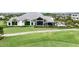Expansive backyard with lush lawn, covered patio seating, and views of the pristine golf course at 4720 Arpino Ct, Bradenton, FL 34211