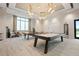 Bright game room features a pool table, ping pong table, lounge seating and ample light from large windows at 4720 Arpino Ct, Bradenton, FL 34211