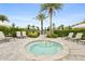 Relaxing hot tub area with lounge chairs and lush landscaping with palm trees and tropical shrubbery at 4720 Arpino Ct, Bradenton, FL 34211