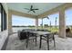 Covered lanai with a dining table and comfortable seating overlooking the water and golf course at 4720 Arpino Ct, Bradenton, FL 34211