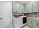 Laundry room featuring side-by-side washer and dryer, built in cabinets and mosaic backsplash at 4720 Arpino Ct, Bradenton, FL 34211