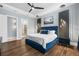 Stylish primary bedroom with a luxurious blue bed, tray ceilings, and an ensuite bathroom at 4720 Arpino Ct, Bradenton, FL 34211