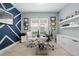 Modern home office features built-in shelving, a geometric accent wall, and plenty of natural light at 4720 Arpino Ct, Bradenton, FL 34211