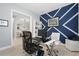 Bright home office offers a workspace with modern decor, a geometric accent wall, and neutral tones at 4720 Arpino Ct, Bradenton, FL 34211
