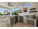 Outdoor kitchen with stainless steel appliances, countertop seating, and a view of the lush landscaping at 4720 Arpino Ct, Bradenton, FL 34211