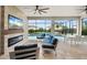 Comfortable outdoor living area with fireplace, TV, and seating, overlooking the beautiful pool and landscaping at 4720 Arpino Ct, Bradenton, FL 34211