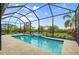 Inviting pool with clear blue water surrounded by a screened enclosure and lush landscaping at 4720 Arpino Ct, Bradenton, FL 34211