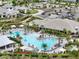 Aerial view of the community pool with a large sun deck, lounge chairs, and lush landscaping at 4720 Arpino Ct, Bradenton, FL 34211