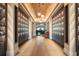 Elegant wine cellar hallway with wooden floors and illuminated wine storage lockers on both sides at 4720 Arpino Ct, Bradenton, FL 34211