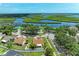 Aerial view of a home with a brown roof near a lake, lush green trees, and an amazing landscape at 4811 14Th E Ave, Bradenton, FL 34208