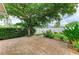 Paver patio in a backyard with lush landscaping, green lawn, mature shade tree, and privacy fence at 4811 14Th E Ave, Bradenton, FL 34208
