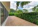 Long brick paver patio with green hedge for privacy outside screened room at 4811 14Th E Ave, Bradenton, FL 34208