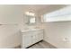 Bathroom features a double vanity with white cabinets, a large mirror, and wood-look flooring at 4811 14Th E Ave, Bradenton, FL 34208
