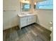 Stylish bathroom featuring a dual sink vanity, gray wood-look floors, and a window for natural light at 4811 14Th E Ave, Bradenton, FL 34208