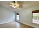 Cozy bedroom with neutral walls, wood-look floors, a ceiling fan, and two windows with views at 4811 14Th E Ave, Bradenton, FL 34208