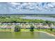 Aerial view showcasing homes with backyard pools along a serene lake, under a sky filled with fluffy clouds at 5142 51St W Ln, Bradenton, FL 34210