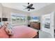 Bright bedroom featuring plantation shutters, a ceiling fan, and access to the en suite bathroom at 5142 51St W Ln, Bradenton, FL 34210
