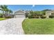Beautiful home with a spacious driveway, lush green lawn, and mature trees, enhanced by well-maintained landscaping at 5142 51St W Ln, Bradenton, FL 34210