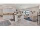 Bright, open kitchen flowing into a sitting area with views of the lake, featuring bar seating and modern finishes at 5142 51St W Ln, Bradenton, FL 34210