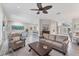 Spacious living area with tile floors, a ceiling fan, comfortable seating, and an open layout with views of the entryway at 5142 51St W Ln, Bradenton, FL 34210