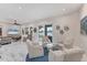 Open-concept living room featuring a sitting area, neutral decor, and sliding glass doors overlooking the lake at 5142 51St W Ln, Bradenton, FL 34210
