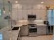 Modern kitchen featuring granite counters, stainless steel appliances and sleek white cabinets at 5219 Barnett Cir, Bradenton, FL 34211