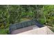 Aerial view showcases the screened-in patio with a spa, nestled among the lush backyard, creating a private retreat at 6744 Hickory Hammock Cir, Bradenton, FL 34202