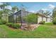 Lush backyard featuring a screened-in patio, in-ground hot tub, and well-maintained landscaping at 6744 Hickory Hammock Cir, Bradenton, FL 34202