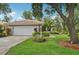 Inviting view of the home's exterior showcasing lush landscaping, a wide driveway, and a well-maintained lawn at 6744 Hickory Hammock Cir, Bradenton, FL 34202