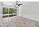 Open living room featuring neutral walls, tile flooring, and sliding doors opening to a screened patio at 6744 Hickory Hammock Cir, Bradenton, FL 34202