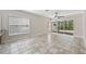 Spacious living room with tile floors, ceiling fan, and sliding glass doors to an outdoor patio at 6744 Hickory Hammock Cir, Bradenton, FL 34202