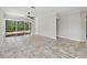Open living room featuring tile flooring, ceiling fan, and sliding doors opening to a screened patio at 6744 Hickory Hammock Cir, Bradenton, FL 34202