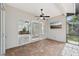 Screened lanai showcasing neutral tile flooring, ceiling fan, and outdoor desert art display at 6744 Hickory Hammock Cir, Bradenton, FL 34202